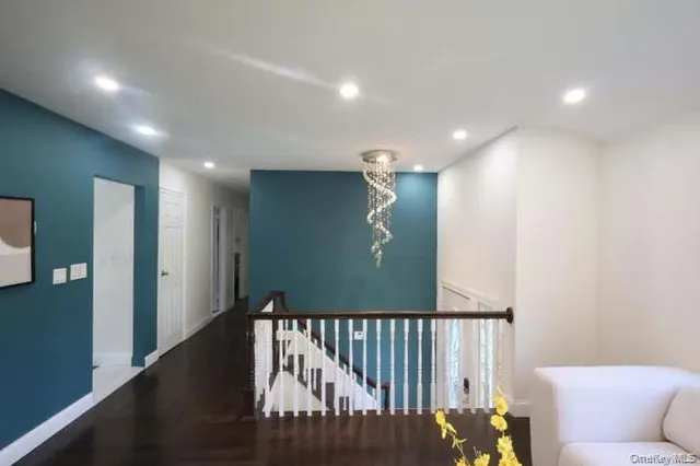 a view of a hallway to a livingroom with furniture