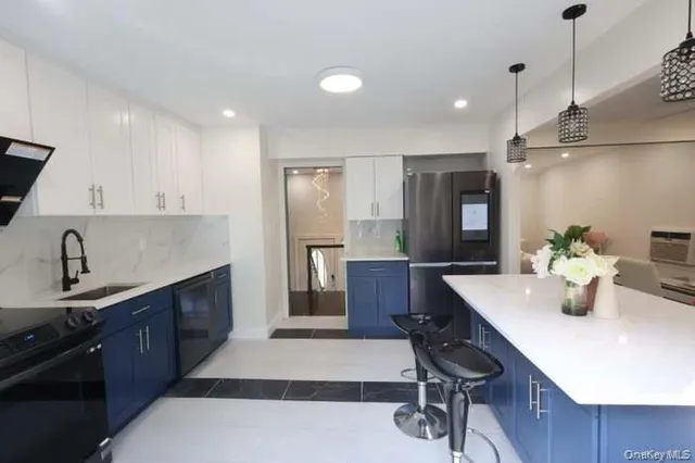 a kitchen with stainless steel appliances kitchen island granite countertop a sink stove and refrigerator