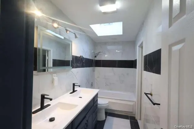 a bathroom with a bathtub a sink and a large mirror