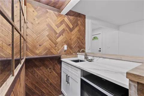 a kitchen with stainless steel appliances granite countertop a sink cabinets and wooden floor