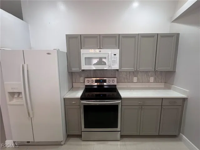 a kitchen with granite countertop white cabinets and white appliances