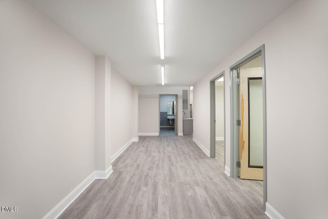 5621 Departure Drive, Unit 101 Raleigh, NC 27616 - Photo 5 of 17 a view of a hallway with wooden floor and a bathroom