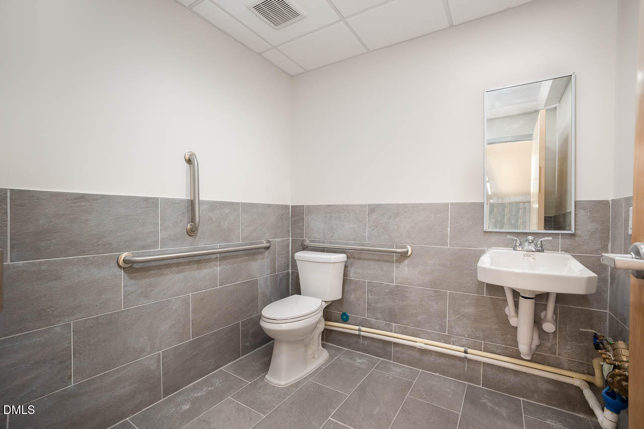 5621 Departure Drive, Unit 101 Raleigh, NC 27616 - Photo 9 of 17 a bathroom with a toilet sink and mirror