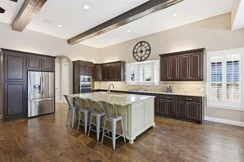 a large kitchen with a table and chairs