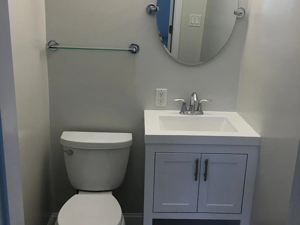 152 Newton Street, Unit 6 Boston, MA 02135 - Photo 7 of 17 a bathroom with a toilet sink and mirror
