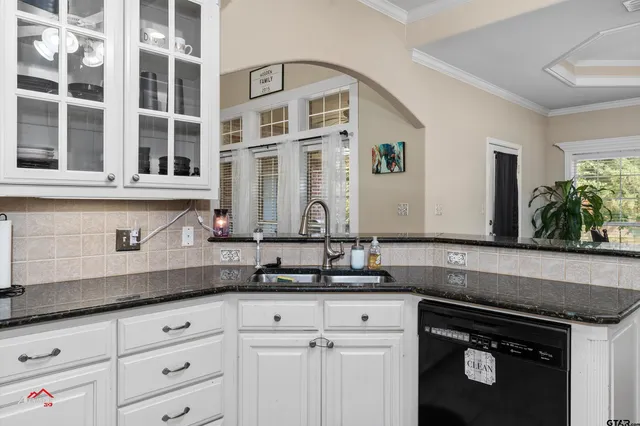 a kitchen with granite countertop a sink and cabinets