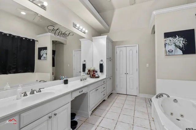 a spacious bathroom with a double vanity sink mirror and bathtub