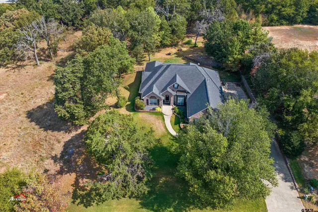 an aerial view of a house with a yard basket ball court and outdoor seating