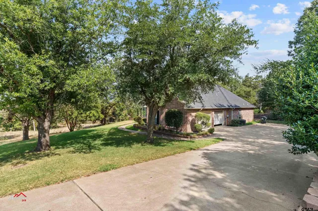 a view of a house with backyard and trees