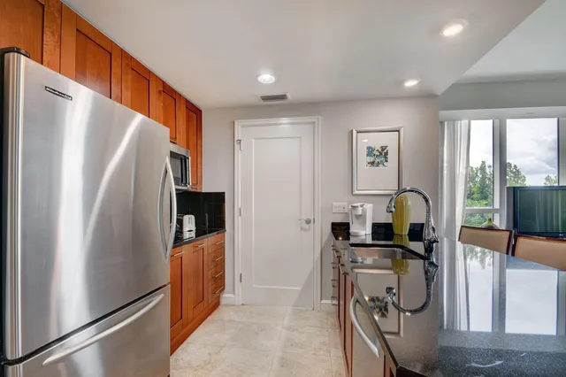 a kitchen with stainless steel appliances granite countertop a refrigerator and a sink