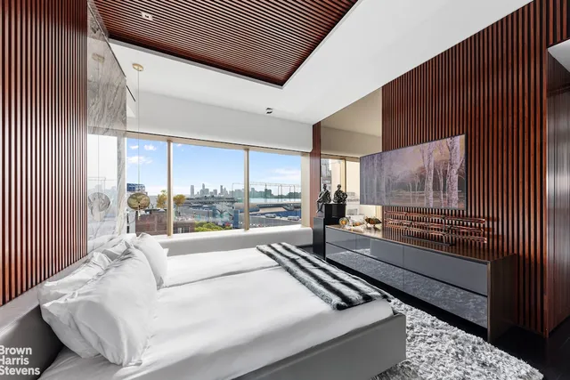 a bedroom with a large bed and a large window with outer view