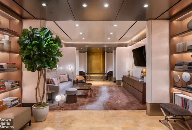 a living room with fireplace furniture and a potted plant