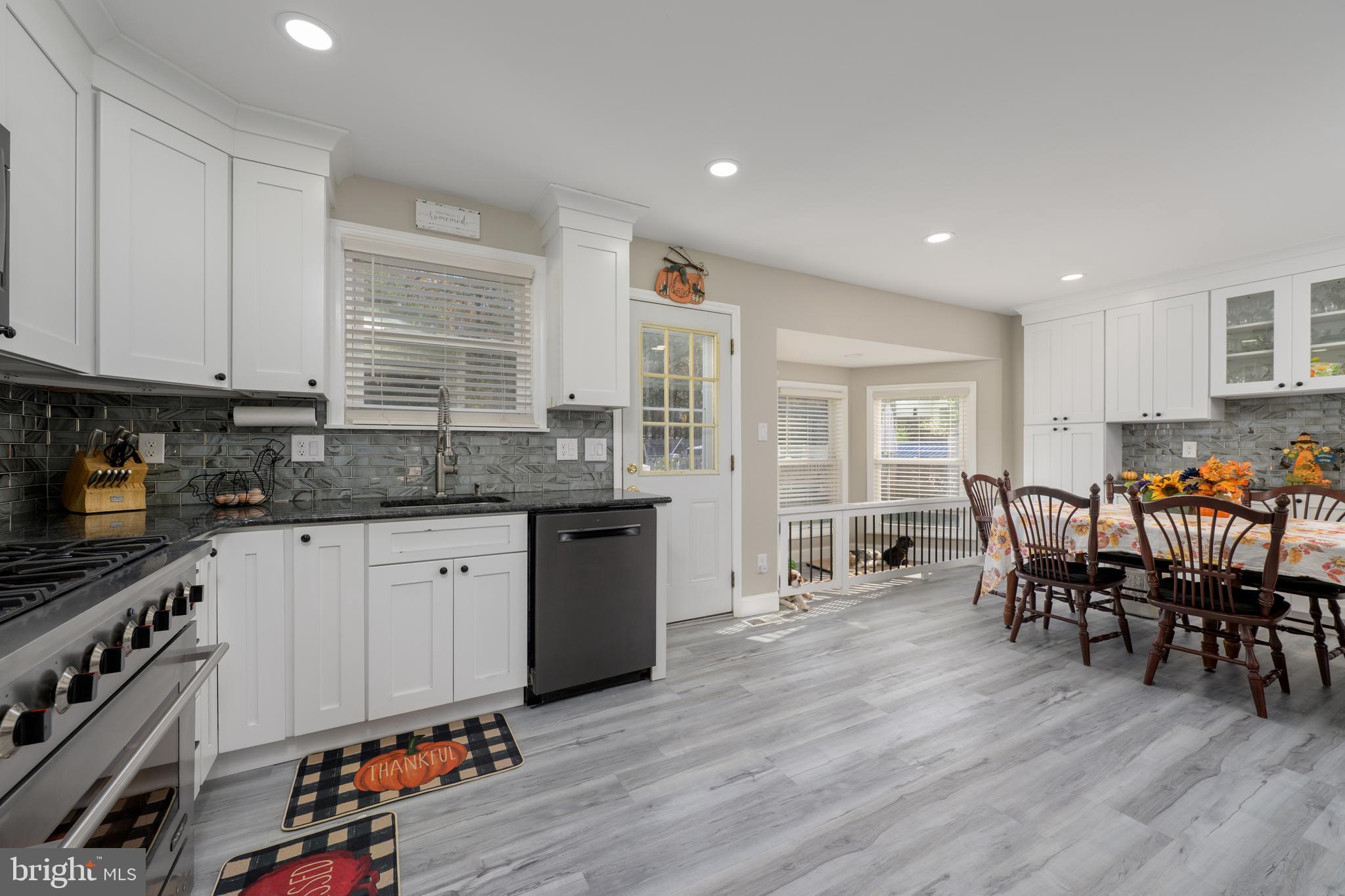 28 Mary Ellen Lane Sicklerville, NJ 08081 - Photo 11 of 46 a kitchen with stainless steel appliances granite countertop a stove top oven a sink a dining table and chairs with wooden floor