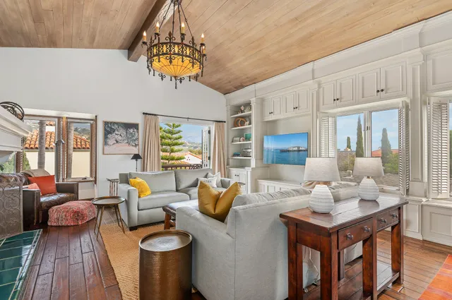 a living room with furniture a chandelier and a dining table