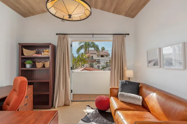 a living room with furniture a rug and wall painting
