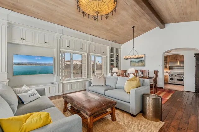 a living room with furniture a rug and kitchen view