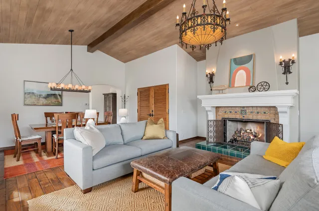 a living room with furniture a chandelier and a fireplace