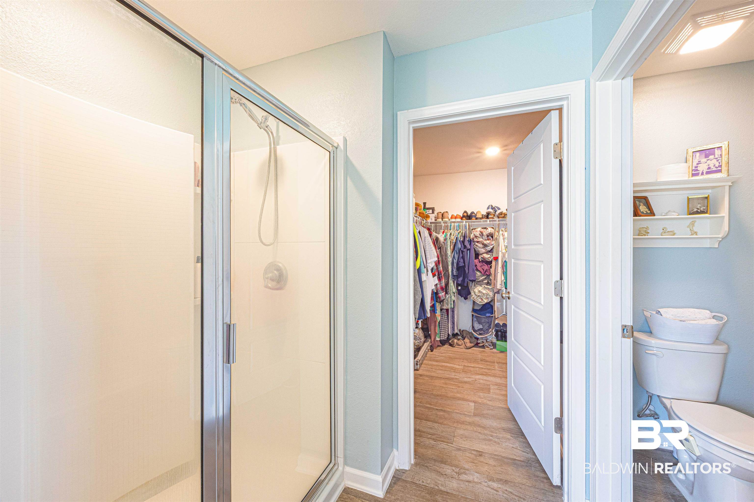 14843 Forsythia Loop Silverhill, AL 36576 - Photo 27 of 51 Full bathroom featuring a walk in closet, a shower stall, and light wood-style floors