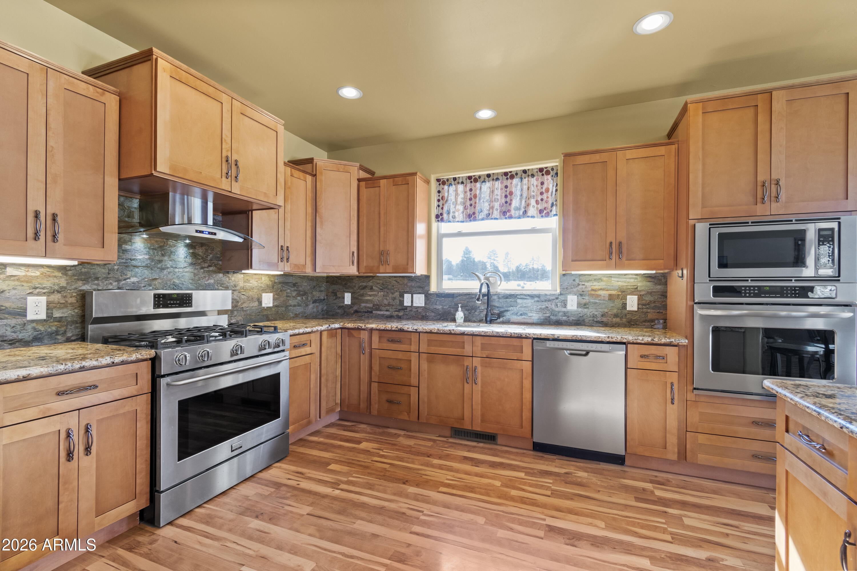816 Fern Way Show Low, AZ 85901 - Photo 15 of 93 a kitchen with stainless steel appliances granite countertop a stove top oven a sink dishwasher and a refrigerator with wooden floor