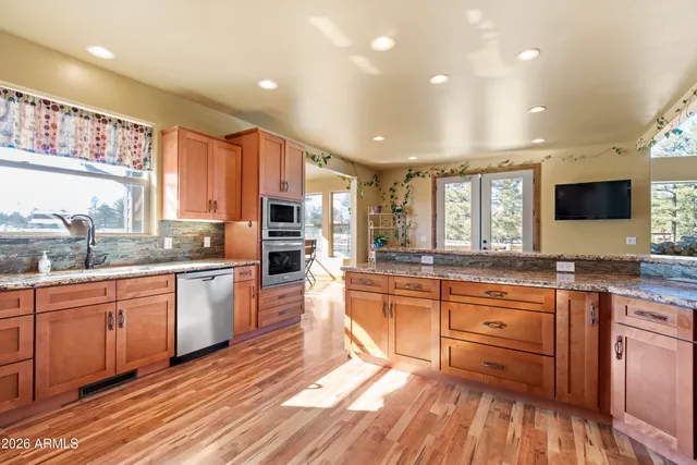 a bed sitting in a spacious bedroom next to a window and a chandelier