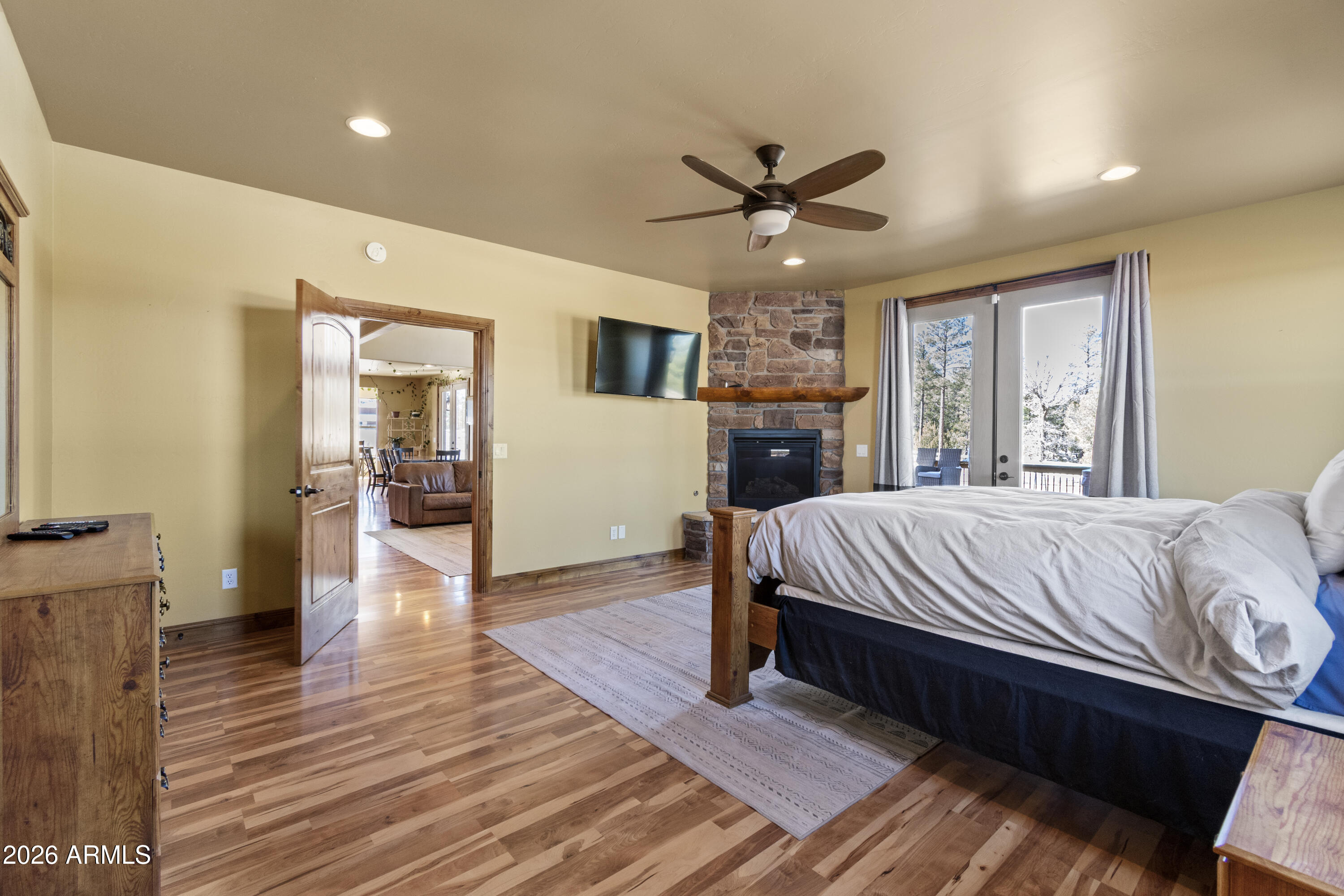 816 Fern Way Show Low, AZ 85901 - Photo 23 of 88 a bed sitting in a spacious bedroom next to a window and a chandelier