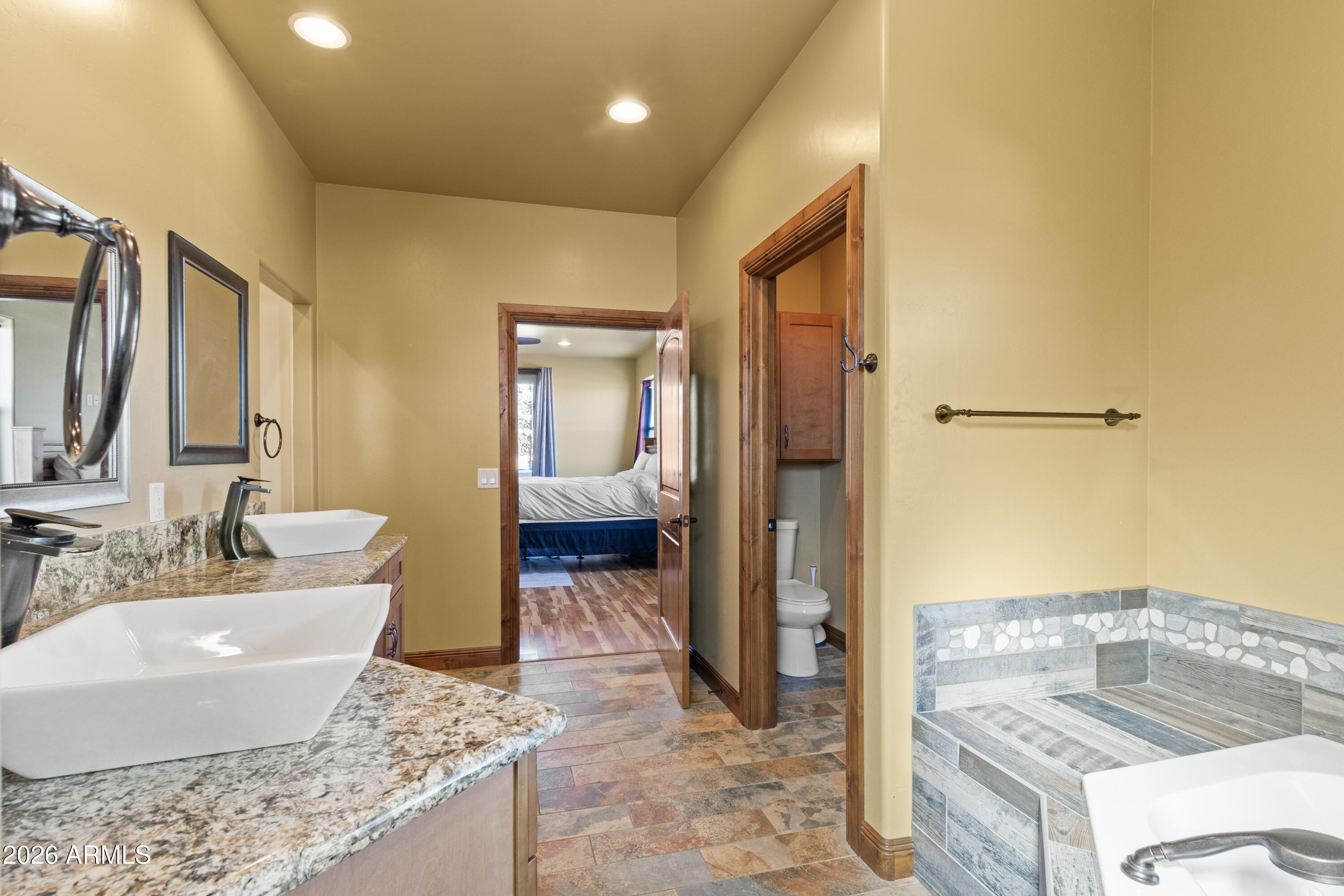 816 Fern Way Show Low, AZ 85901 - Photo 29 of 93 a spacious bathroom with a granite countertop sink and a mirror