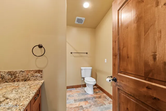 a bedroom with a bed and a large window with wooden floor