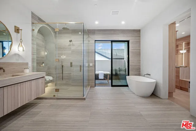 a bathroom with a granite countertop sink a toilet a mirror and shower