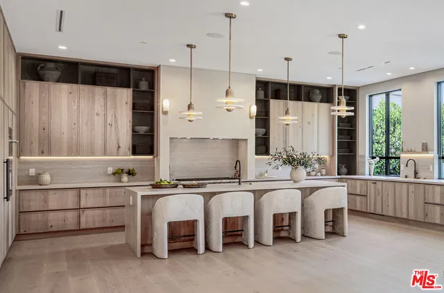 a kitchen with kitchen island granite countertop a sink and a refrigerator