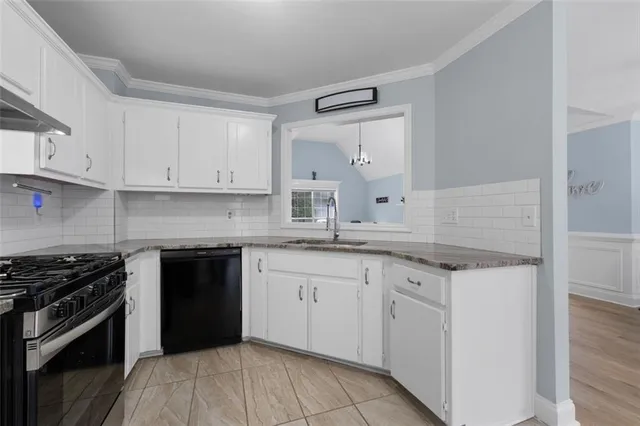 a kitchen with granite countertop white cabinets and stainless steel appliances