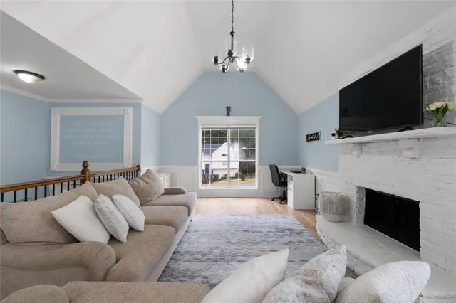 a living room with furniture a flat screen tv and a fireplace