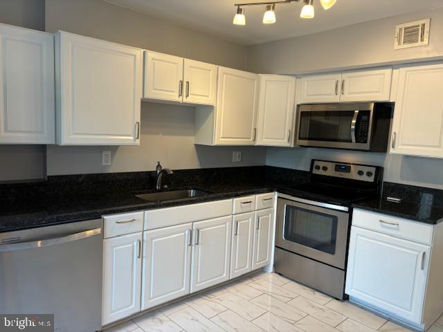 7900 Spring Forest Court Springfield, VA 22152 - Photo 9 of 40 a kitchen with granite countertop white cabinets sink and stainless steel appliances