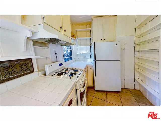 a kitchen with stainless steel appliances a stove a refrigerator and a cabinets
