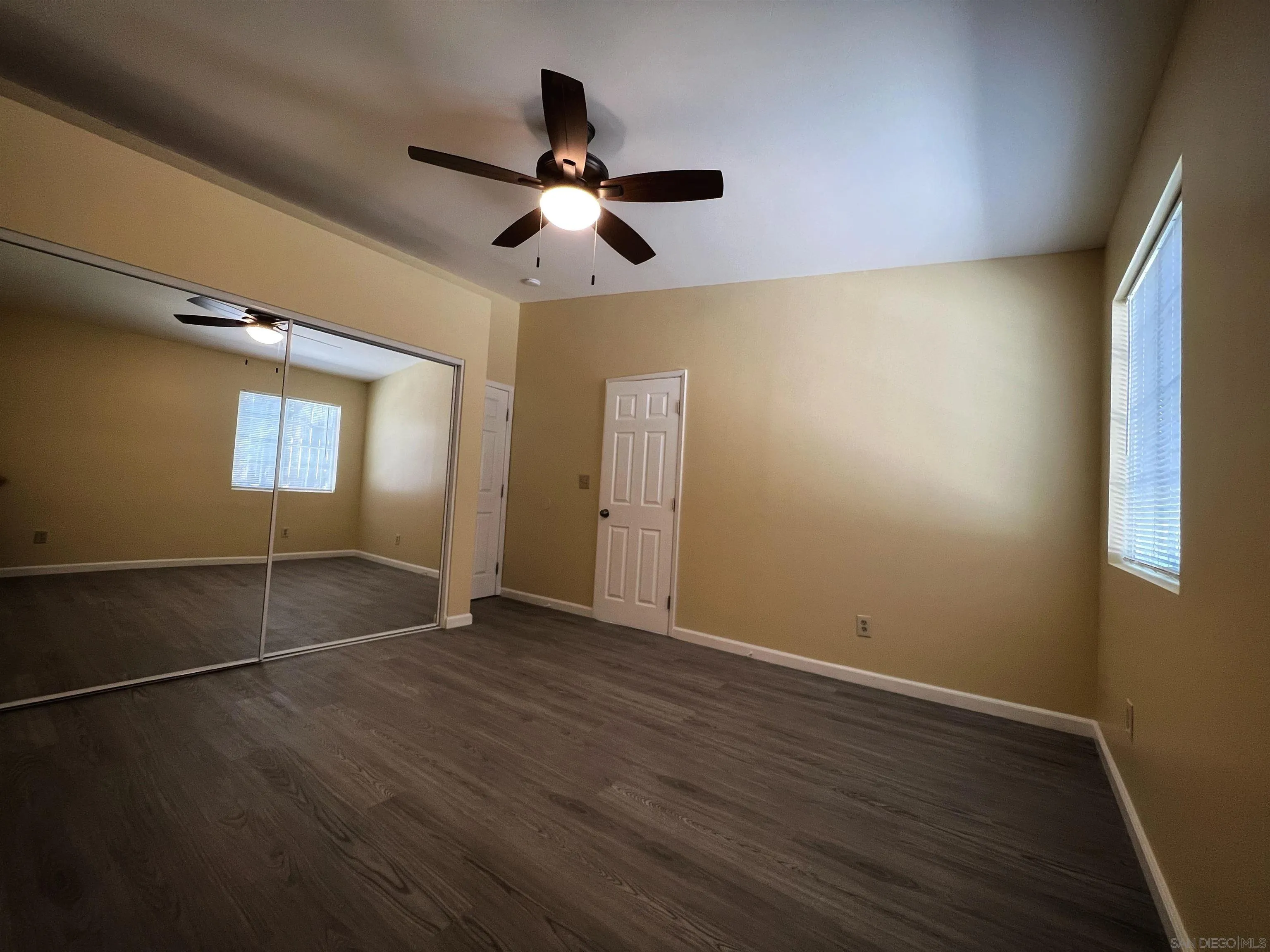 714 Convertible Lane Fallbrook, CA 92028 - Photo 14 of 28 an empty room with wooden floor fan and windows