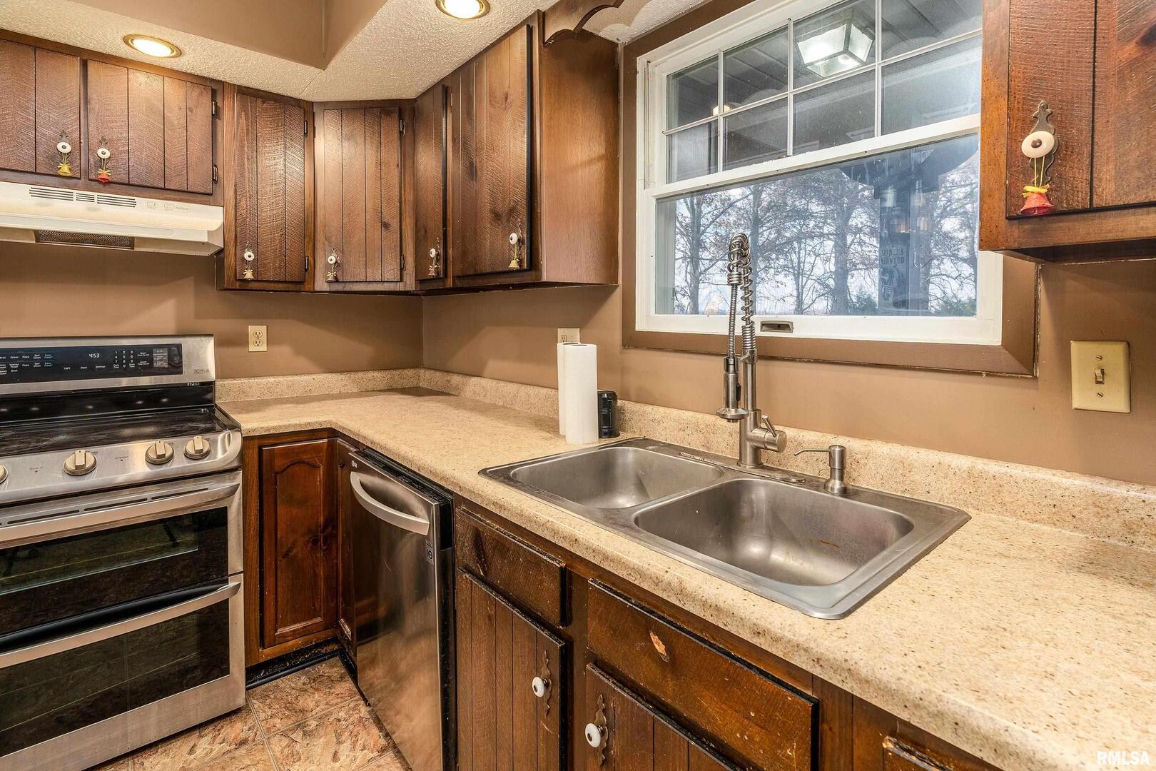 18662 Liberty School Road Thompsonville, IL 62890 - Photo 15 of 32 a kitchen with a sink and a stove next to a large window