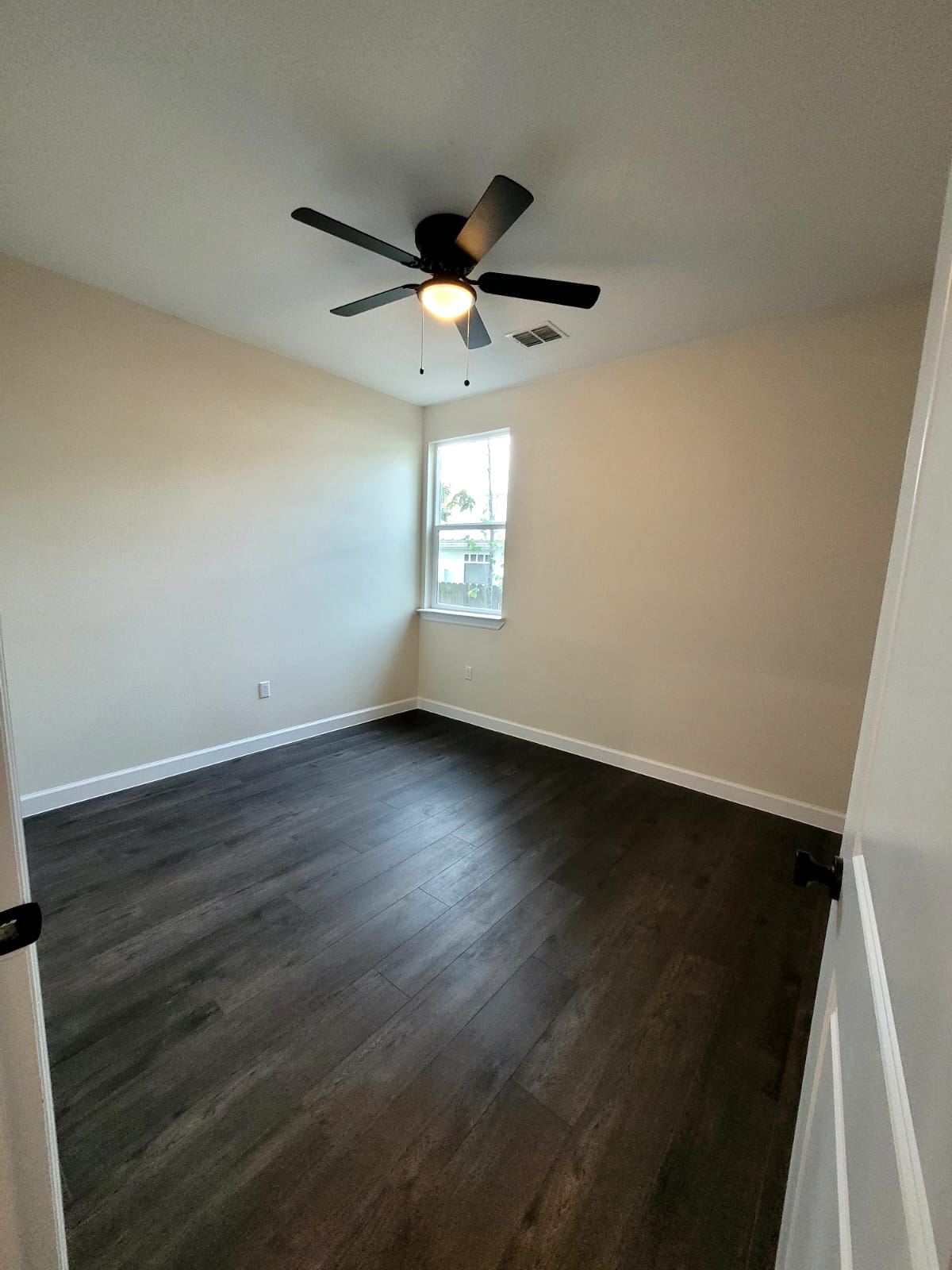 750 South Main Street Lockhart, TX 78644 - Photo 14 of 31 Empty room with dark wood finished floors and ceiling fan