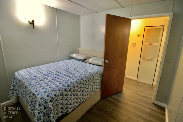 a bedroom with a bed and wooden floor