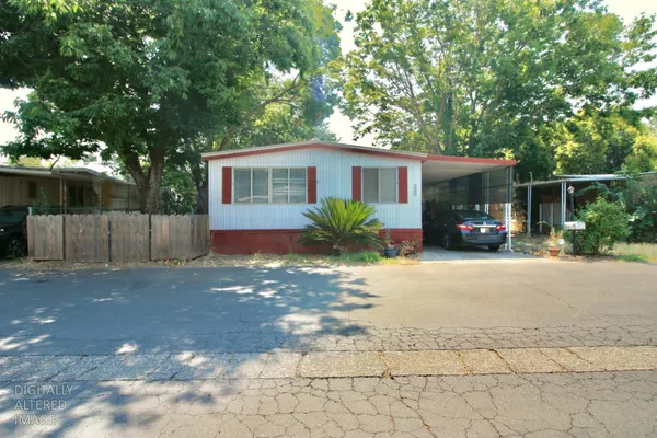 a view of a house with backyard and a tree
