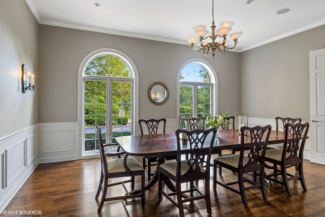 a view of a dining room with furniture a chandelier and wooden floor