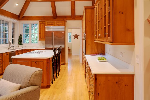 a kitchen with stainless steel appliances granite countertop a kitchen island a stove a table and a refrigerator