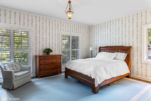 a bedroom with a bed and next to a window