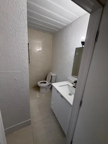 a bathroom with a sink a toilet and mirror