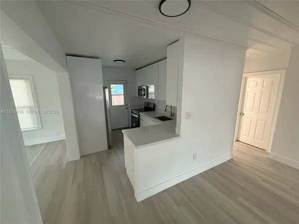 a view of a hallway with wooden floor and furniture