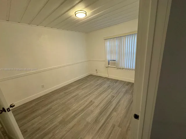 a view of a room with wooden floor and a window