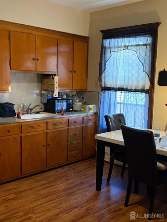 a kitchen with a table chairs a sink dishwasher window and cabinets