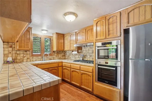 a kitchen with stainless steel appliances granite countertop a refrigerator and a stove top oven