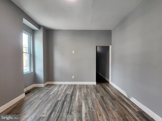 a view of a room with wooden floor and window
