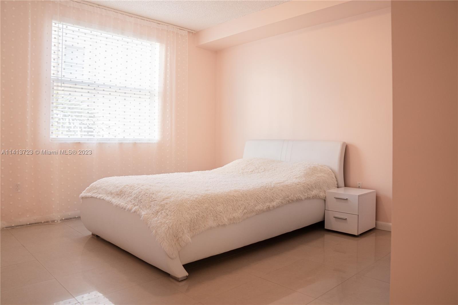 17100 North Bay Road, Unit 1613 Sunny Isles Beach, FL 33160 - Photo 19 of 30 a bed sitting in a bedroom next to a window