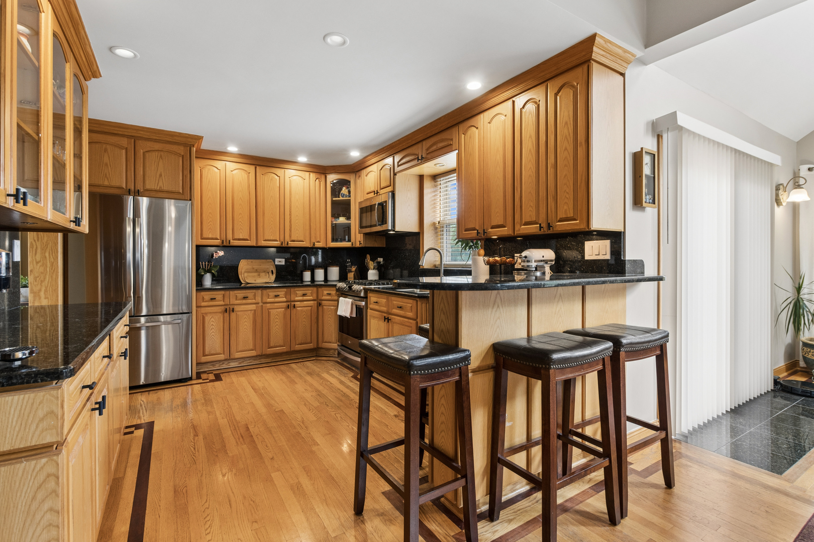 7911 West Rascher Avenue Chicago, IL 60656 - Photo 17 of 39 a kitchen with granite countertop a refrigerator a sink a stove a dining table and chairs