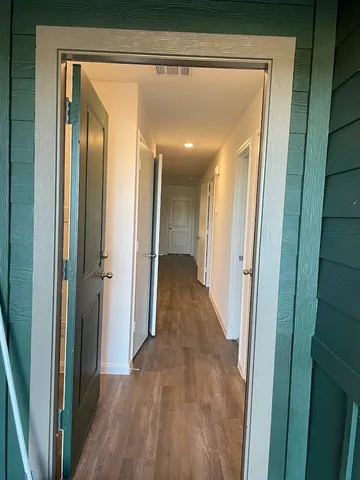 a view of a hallway with wooden floor